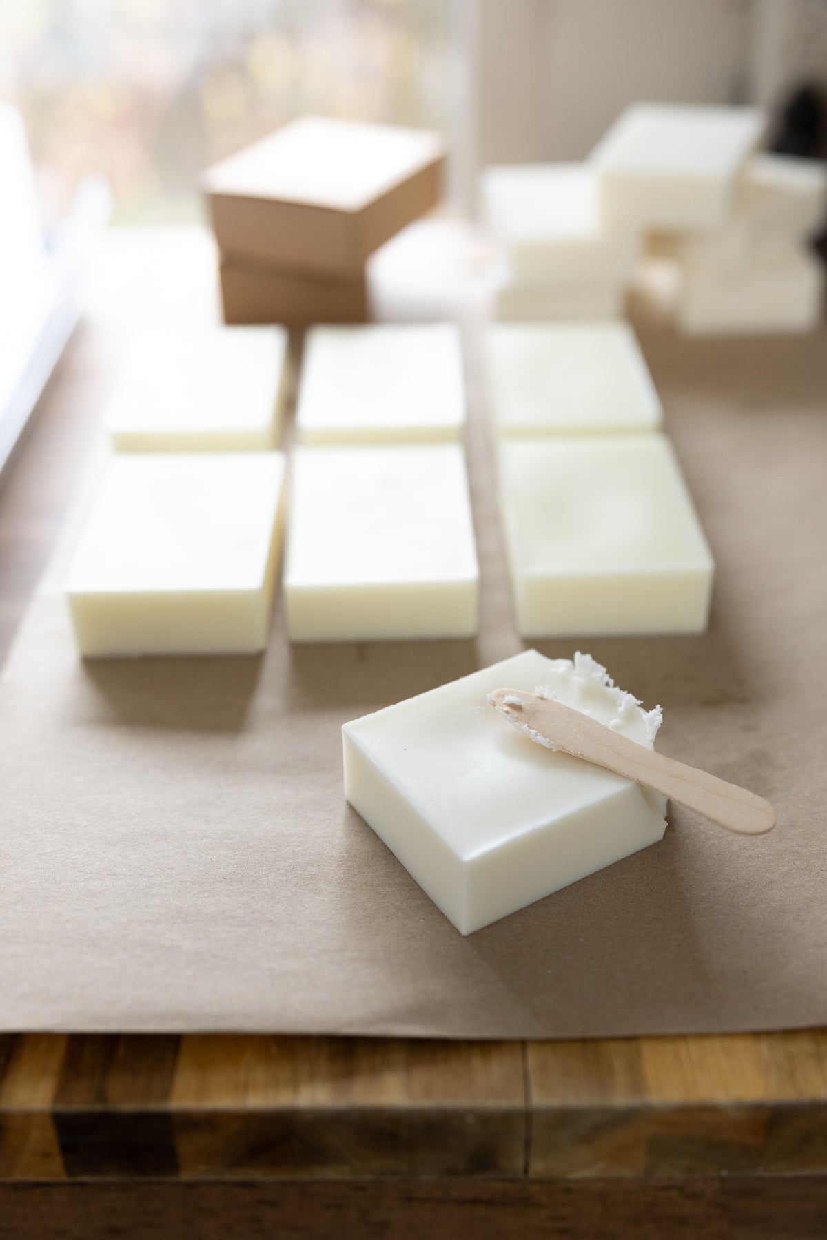 Salt + Ember soy wax bars on kraft paper with a wooden scoop